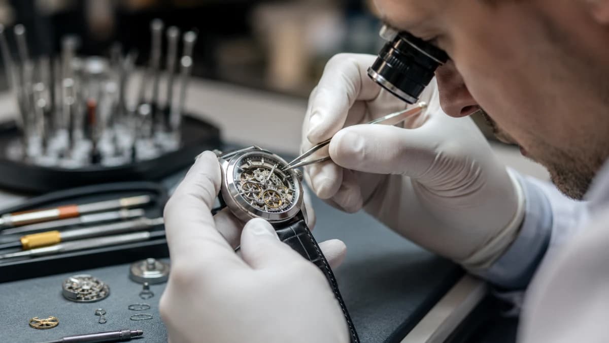 Uhrmacher prüft eine hochwertige mechanische Uhr mit Präzisionswerkzeug
